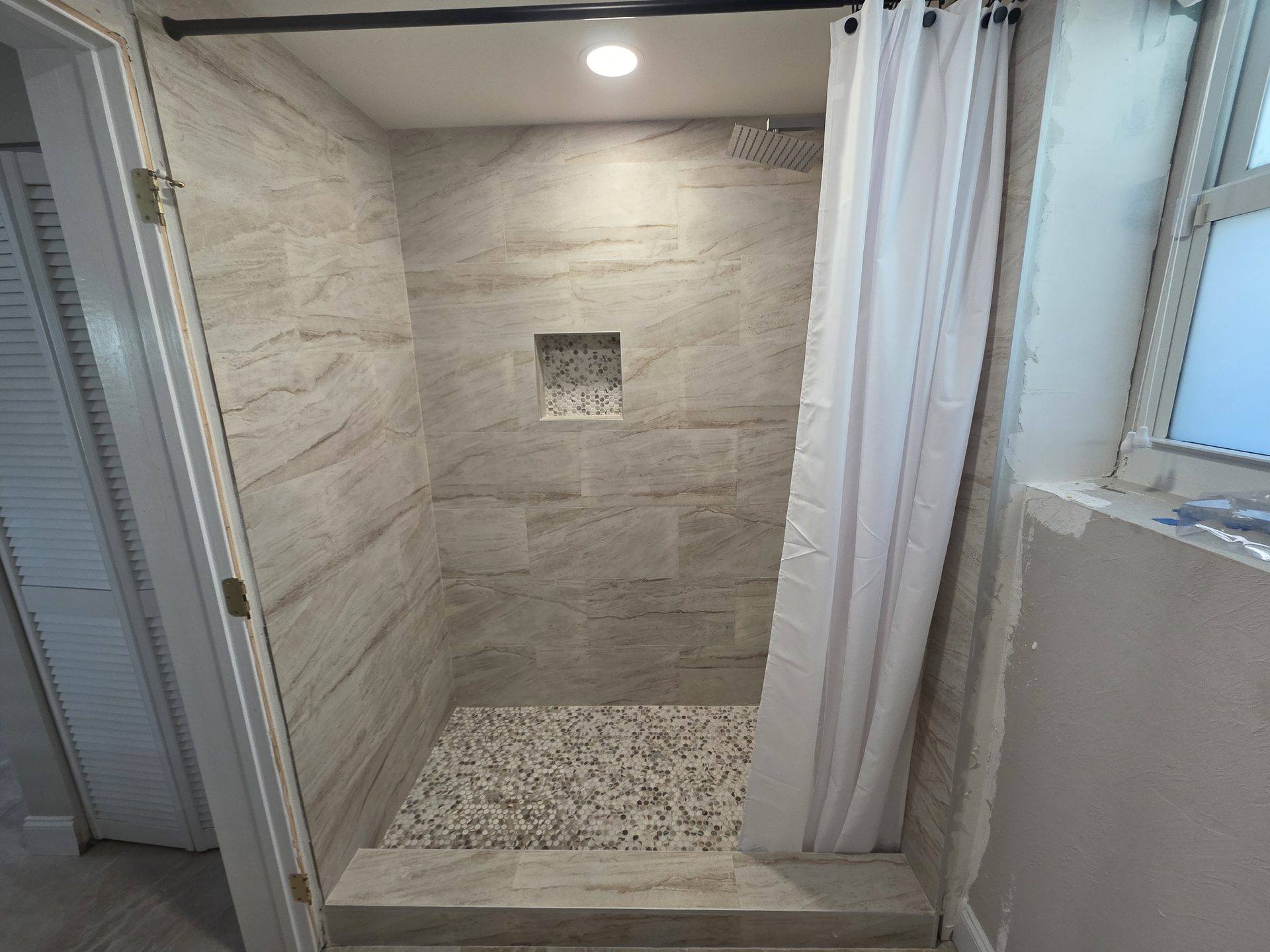 Firenova bathroom remodel with stone-look tile and shower niche
